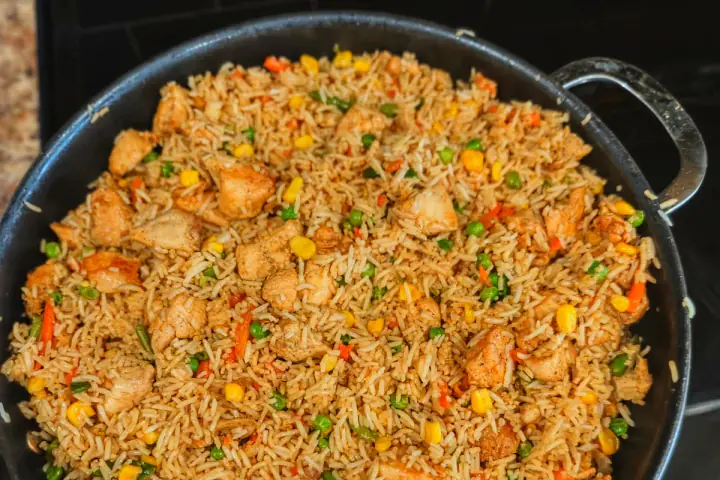 Chicken fried rice with mixed vegetables in a large pan