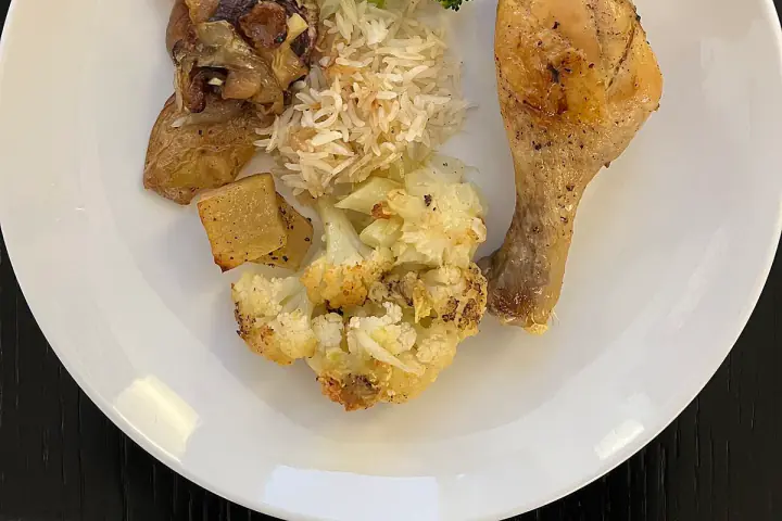 Roasted chicken with rice, broccoli, cauliflower, potatoes, and salad