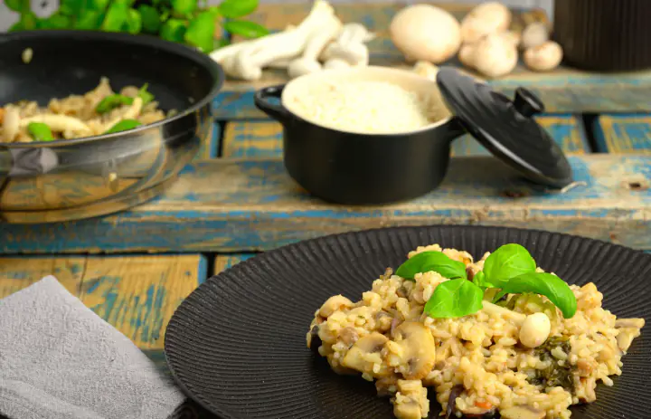 Creamy mushroom rice with basil on a black plate