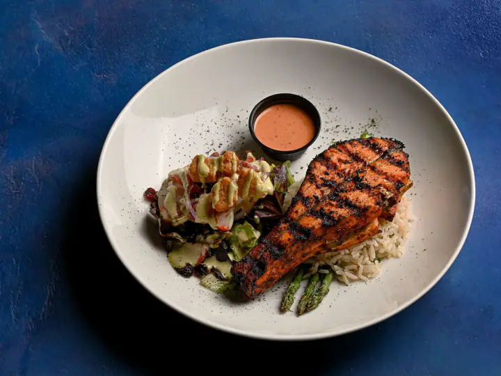 Grilled salmon with rice, asparagus, greens, and dressing